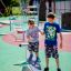 Two children playing on the Wonderland Trim Trail in a park.