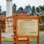 Rules Tab playground sign on wooden frame near climbing net structure