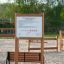 Rules Tab playground equipment wooden sign with safety regulations displayed on a sandy play area