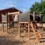 Playground structure Challenger Aztec Nature II with climbing nets and slides.
