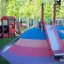 Locomotive with slide train playhouse in a colorful playground.