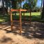 Wooden horizontal ladder playground equipment standing in a park.