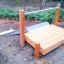 Wooden play structure with Hill Slide Wide h120 in a park.