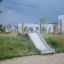Hill Slide Wide h120 outdoor playground slide on a grassy hill.