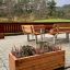 Wooden flowerpot II with heather on a terrace.