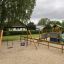 Swing Frame (double swing) in a playground with a slide and climbing structures.