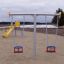 Swing Metal Frame (double swing) in playground with yellow slide in the background.