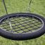 Swing seat: Bird's nest seat with black rope design hanging on a green grassy background.