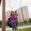 Girl sitting on a Tire seat swing in a playground.
