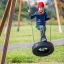 Child playing on Tire seat swing in the playground.