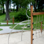 Panther wooden playhouse in a park with green trees and sandy ground