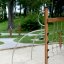 Panther wooden playhouse in a park with green trees and sandy ground