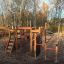 Panther wooden playhouse with slides and climbing structures in a playground