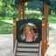 Child playing in Locomotive Nature train playhouse on playground.