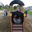 Children playing on the Locomotive Nature train playhouse in a sandbox.