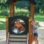 Children playing in the Locomotive Nature train playhouse on a playground.