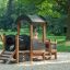 Locomotive Nature train playhouse on a playground with a child playing inside.