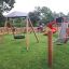Natural wooden playground with Locomotive Nature train playhouse, swings, slides, and climbing nets.