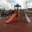 Challenger-Aztec wooden playhouse with slide and climbing wall on playground