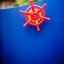 Red steering wheel on blue Pi playground equipment.