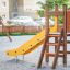 Pi playground yellow slide with wooden steps in a sandbox area