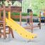 A yellow slide on a wooden playground structure in a park.