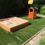 Playground with sandpit and Bravo single playhouse on artificial grass.