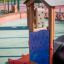 Wooden smart playhouse with slide and alphabet board on a playground.