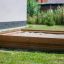 Wooden sandpit in a backyard.