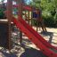 Zebra single slide in a playground with a red slide and climbing features