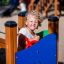 A little girl playing on the Zebra single slide playground.