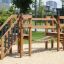 Wooden playground Bridge on sandy surface with climbing stairs and bridge.