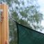 Sun Shade Triangle 5x5x5 Pioneer (Larchwood) attached to wooden post.