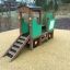 Playground Tractor-shaped climbing structure with slide on rubber surface