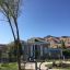 Set 4 outdoor fitness equipment in a landscaped park with mountains in the background.