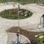 Outdoor fitness park with various exercise equipment and greenery.