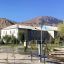 Outdoor fitness equipment in a park with mountains and buildings in the background.