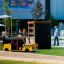 Children's playground taxi-shaped play structure with a climbing wall in the background.