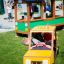 Children playing in a yellow Taxi-themed playground vehicle.