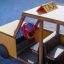 Playground wooden taxi with a red steering wheel.