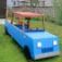 Blue play Truck with red roof and wooden frame in a backyard.