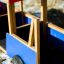 Wooden toy truck with red roof and blue sides for children.