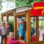 Children playing on a wooden fire brigade car in playground.