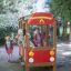 Children playing on a Fire brigade car playground equipment in a park.