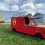 Fire brigade truck toy on playground in front of colorful mural.