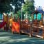 Gamma playground complex with slides and bridges in a park setting.