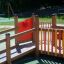 Playground equipment Gamma with wooden railings and colorful panels.