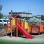 Gamma playground set with slides and climbing structures in a park