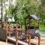 Gamma playground structure with wooden ramp and house in park setting