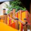 Gamma wooden playground equipment for children, featuring colorful slides and climbing structures.